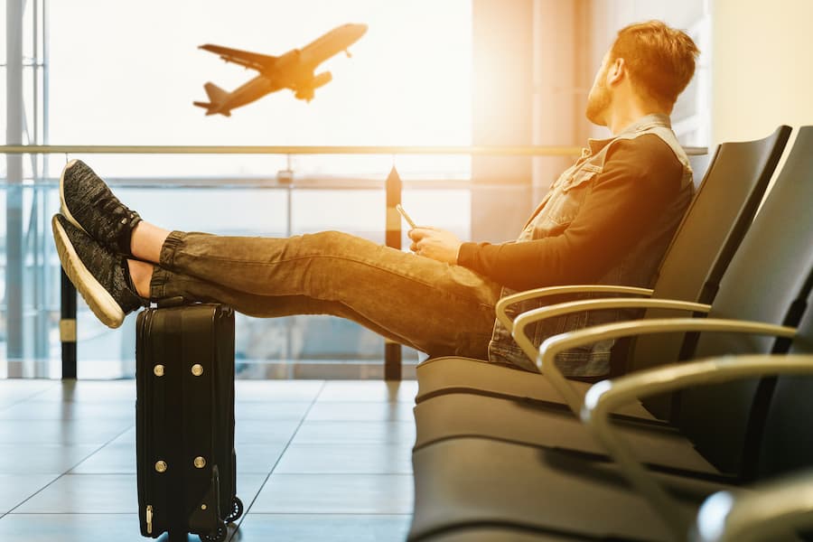 Man sitting on a chair with feet on a luggage.